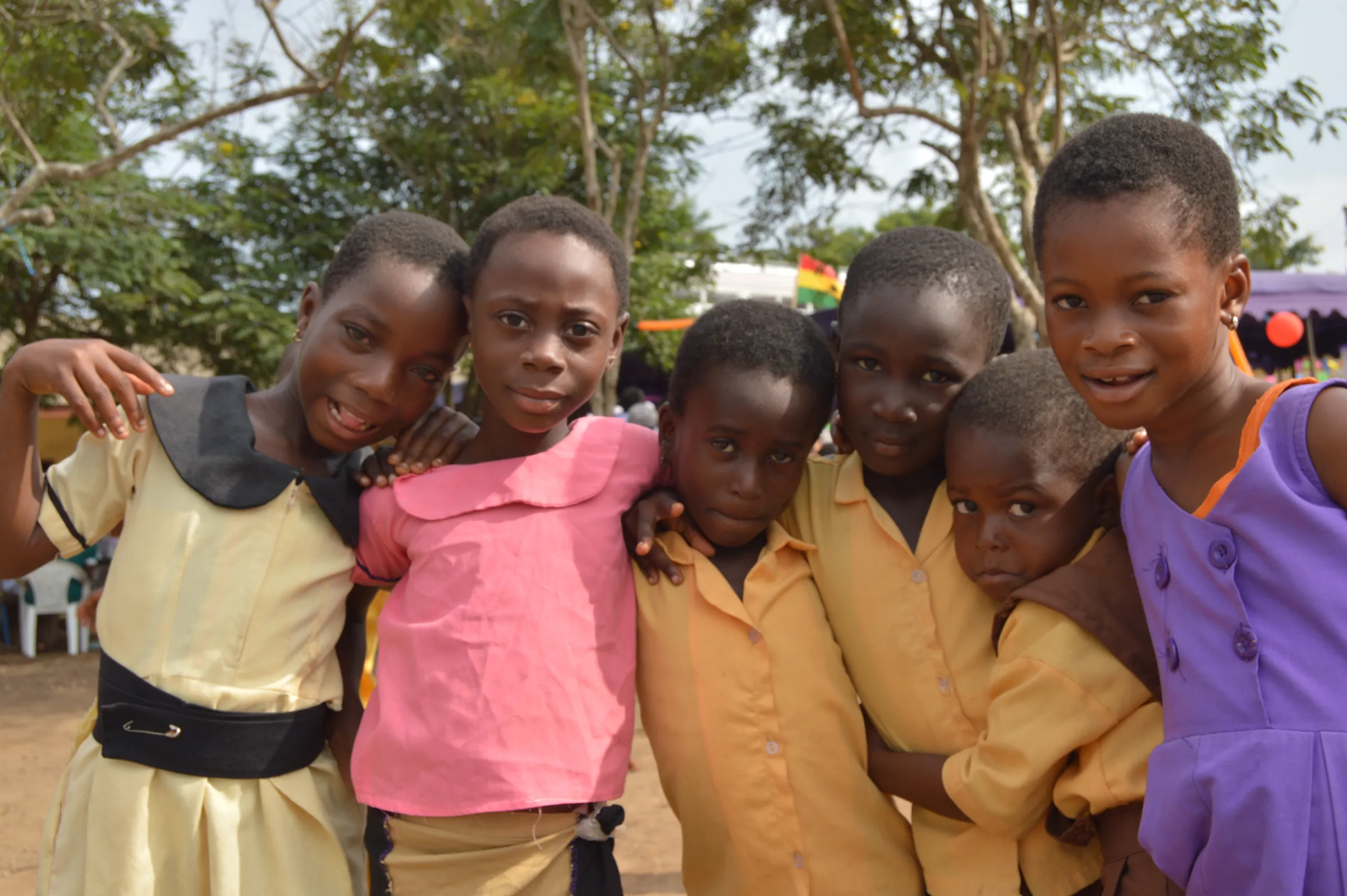 A group of smiling schoolgirls standing together outdoors